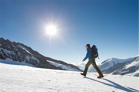 Man hiking across snow covered mountain landscape, Jungfrauchjoch, Grindelwald, Switzerland Stock Photo - Premium Royalty-Free, Code: 649-08085717