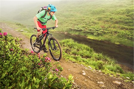 Young male mountain biker cycling next to stream Stock Photo - Premium Royalty-Free, Code: 649-08086066