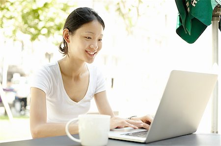 Young female tourist typing on laptop at sidewalk cafe, The Bund, Shanghai, China Foto de stock - Sin royalties Premium, Código: 649-08086331