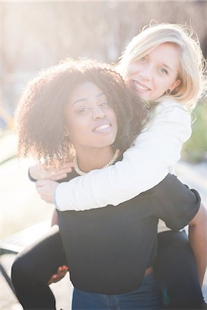 simsearch:649-07736862,k - Portrait of two female friends giving piggy backs in park Stock Photo - Premium Royalty-Free, Code: 649-08086414