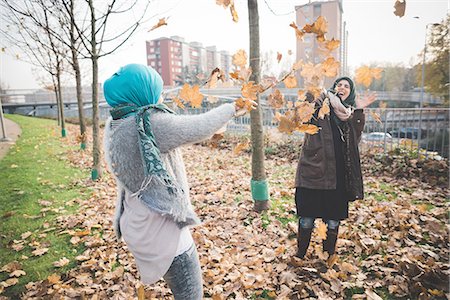 simsearch:649-08117852,k - Two young women play fighting with autumn leaves in park Foto de stock - Sin royalties Premium, Código: 649-08086849