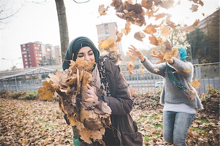 simsearch:649-08117852,k - Two young women friends play fighting with autumn leaves in park Foto de stock - Sin royalties Premium, Código: 649-08086850