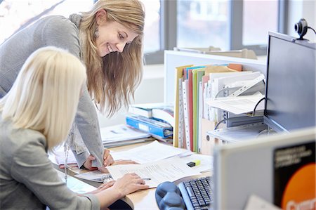 simsearch:649-07736470,k - Two businesswomen checking paperwork at office desk Stock Photo - Premium Royalty-Free, Code: 649-08117819