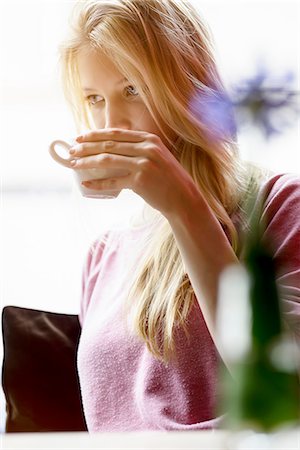 Young woman in cafe window seat drinking coffee Stock Photo - Premium Royalty-Free, Code: 649-08117913