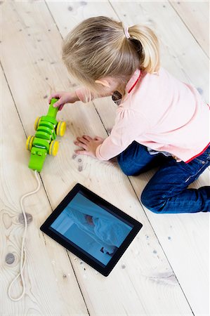 simsearch:649-07064267,k - Girl with digital tablet, playing toy on wooden floor Stock Photo - Premium Royalty-Free, Code: 649-08118184