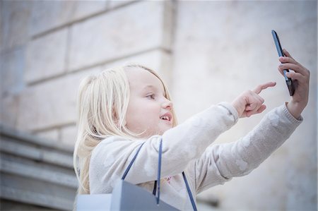 Young girl on stairway using touchscreen on smartphone, Cagliari, Sardinia, Italy Stock Photo - Premium Royalty-Free, Code: 649-08118442