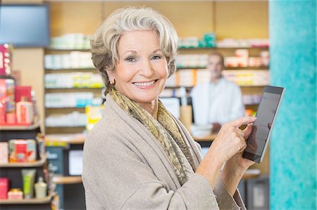 Portrait of senior woman using digital tablet to check medicine online in pharmacy Foto de stock - Sin royalties Premium, Código: 649-08118520