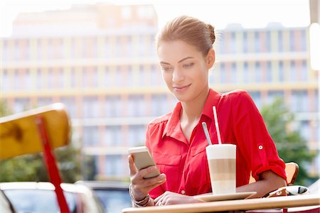simsearch:649-07238896,k - Young woman sitting outside cafe, using mobile phone Stock Photo - Premium Royalty-Free, Code: 649-08118638