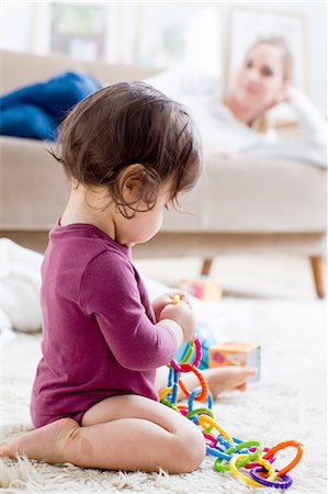 fat lady sitting - Mother lying on sofa watching baby boy play on floor Stock Photo - Premium Royalty-Free, Code: 649-08118747