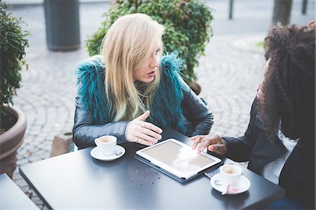 friends talking outside - Two young women using digital tablet at sidewalk cafe, Lake Como, Como, Italy Stock Photo - Premium Royalty-Free, Code: 649-08118800