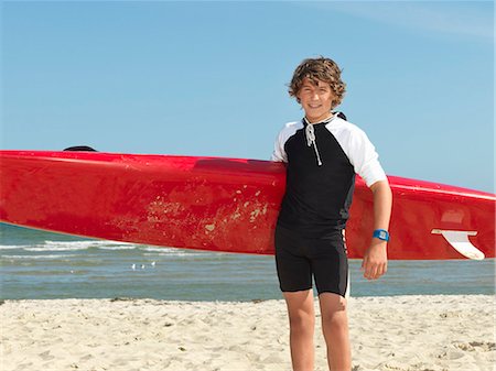 Portrait of teenage boy nipper (child surf life savers) with surfboard, Altona, Melbourne, Australia Stock Photo - Premium Royalty-Free, Code: 649-08125347