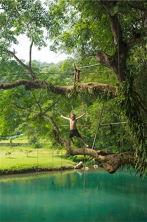 simsearch:649-08117852,k - Mature man jumping mid air into turquoise lagoon, Vang Vieng, Laos Foto de stock - Sin royalties Premium, Código: 649-08125422