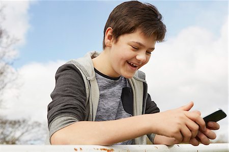 simsearch:649-07648247,k - Smiling teenage boy reading smartphone text message Stock Photo - Premium Royalty-Free, Code: 649-08125597
