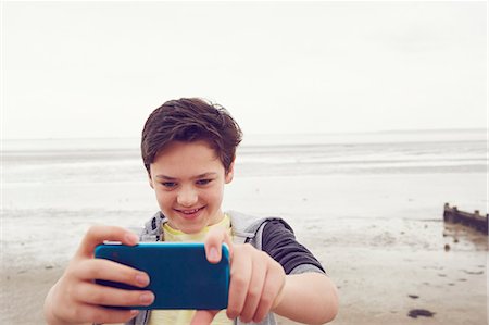 simsearch:649-07648247,k - Smiling teenage boy taking smartphone selfie at seaside, Southend on Sea, Essex, UK Stock Photo - Premium Royalty-Free, Code: 649-08125631