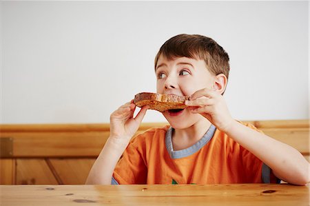 Young boy eating piece of toast Foto de stock - Sin royalties Premium, Código: 649-08125798