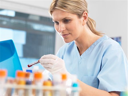 Medical researcher viewing data on a computer for a blood sample during testing Stock Photo - Premium Royalty-Free, Code: 649-08125915