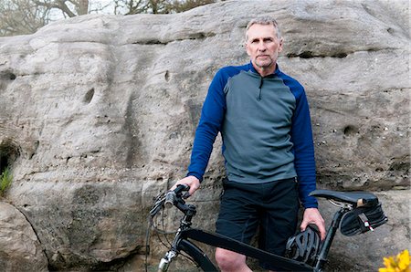 Portrait of male mountain biker on rock formation Stock Photo - Premium Royalty-Free, Code: 649-08125989