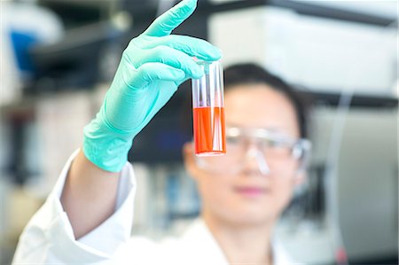 simsearch:649-08085222,k - Young female lab technician holding up orange sample in lab Stock Photo - Premium Royalty-Free, Code: 649-08126033