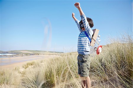 simsearch:649-06845253,k - Young boy on beach, wearing fancy dress, arms raised Stock Photo - Premium Royalty-Free, Code: 649-08144177