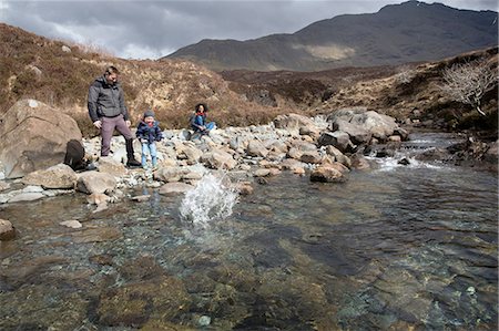 Family throwing stones in pond, Fairy Pools, Isle of Skye, Hebrides, Scotland Stock Photo - Premium Royalty-Free, Code: 649-08144538