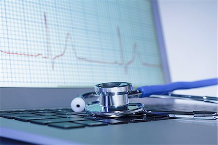 Modern cardiology. Acoustic stethoscope on a laptop computer displaying ECG trace Stock Photo - Premium Royalty-Free, Code: 649-08144854