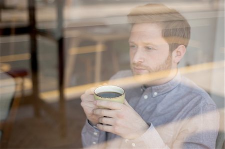 simsearch:649-07238896,k - Male customer behind cafe window drinking coffee and gazing Stock Photo - Premium Royalty-Free, Code: 649-08145034