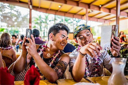 Two young men reading menu in Polynesian Cultural Centre, Hawaii, USA Stock Photo - Premium Royalty-Free, Code: 649-08145063