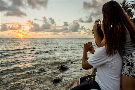 Couple photographing sunrise on smartphones, Kaaawa beach, Oahu, Hawaii, USA Stock Photo - Premium Royalty-Free, Code: 649-08145085