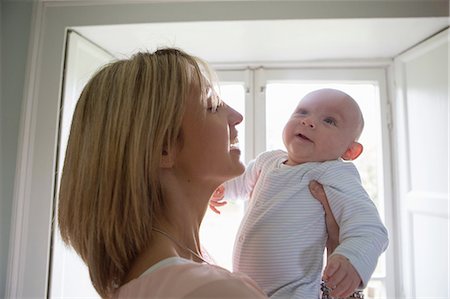 pictures for mothers with their babies or kids - Portrait of smiling mother holding new baby boy Stock Photo - Premium Royalty-Free, Code: 649-08145285