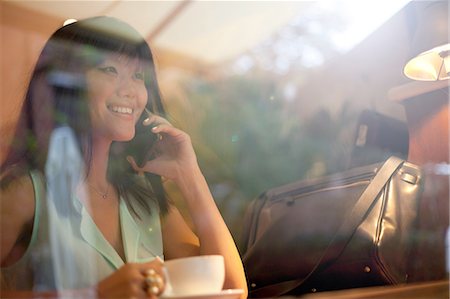 Young woman drinking coffee in cafe, using smartphone, Shanghai, China Stock Photo - Premium Royalty-Free, Code: 649-08145348