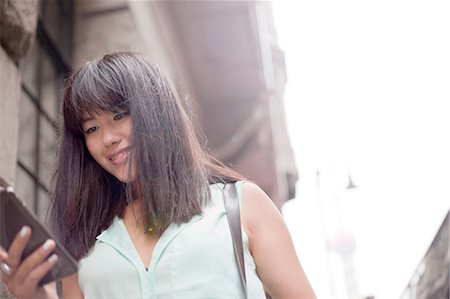 Young businesswoman, using smartphone, outdoors, Shanghai, China Stock Photo - Premium Royalty-Free, Code: 649-08145350