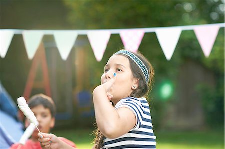 simsearch:649-08180244,k - Girl eating toasted marshmallows in garden Stock Photo - Premium Royalty-Free, Code: 649-08180242