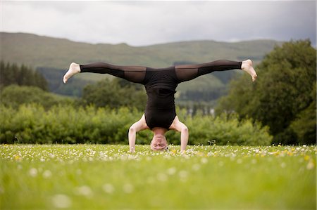 simsearch:614-06168927,k - Mature woman practicing yoga standing on head with legs open in field Stock Photo - Premium Royalty-Free, Code: 649-08180514
