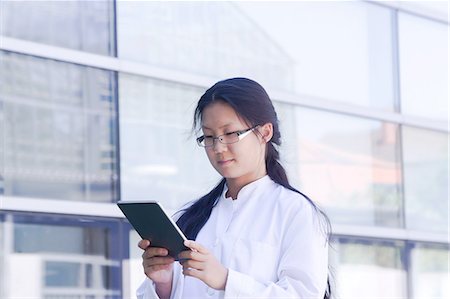 simsearch:649-07585094,k - Young female scientist reading digital tablet outside laboratory Stock Photo - Premium Royalty-Free, Code: 649-08180583