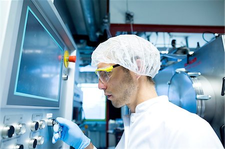 simsearch:649-08085222,k - Male scientist adjusting switch on control panel in lab cleanroom Stock Photo - Premium Royalty-Free, Code: 649-08180597