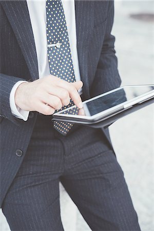 simsearch:649-07560130,k - Cropped view of businessman using digital tablet touchscreen Stock Photo - Premium Royalty-Free, Code: 649-08237692