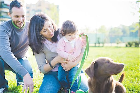 Mid adult couple with toddler daughter and dog in park Stock Photo - Premium Royalty-Free, Code: 649-08238419