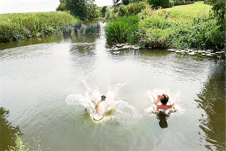 simsearch:649-07648247,k - Young man and teenage boy splashing into rural lake Stock Photo - Premium Royalty-Free, Code: 649-08238770