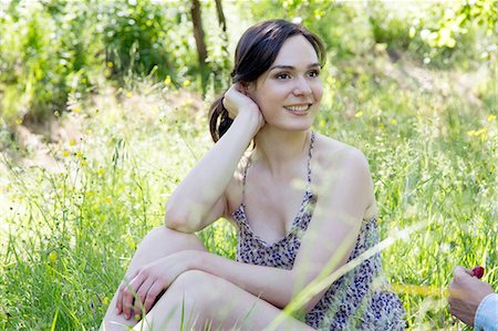 simsearch:649-08239088,k - Young woman sitting on grass looking away smiling Stock Photo - Premium Royalty-Free, Code: 649-08239077