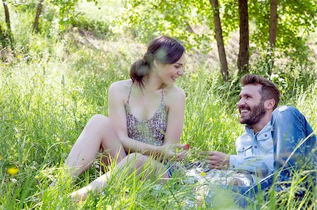 simsearch:649-08239088,k - Young couple lying on grass face to face eating strawberries smiling Stock Photo - Premium Royalty-Free, Code: 649-08239078