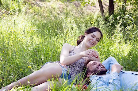 simsearch:649-08239088,k - Young couple lying on grass eating strawberries smiling Stock Photo - Premium Royalty-Free, Code: 649-08239079