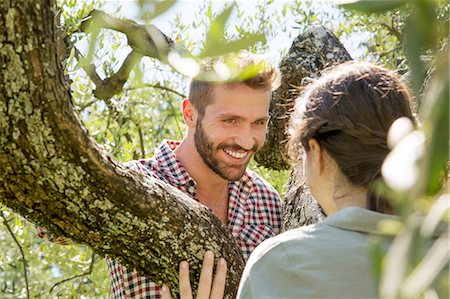 simsearch:649-08239088,k - Young couple in tree face to face smiling Stock Photo - Premium Royalty-Free, Code: 649-08239070