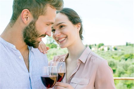 simsearch:649-08239088,k - Young couple holding wine glasses face to face smiling Stock Photo - Premium Royalty-Free, Code: 649-08239104