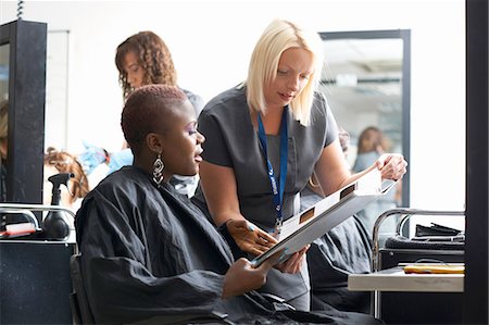 simsearch:6118-08660009,k - Young woman in hair salon wearing hair cutting cape choosing hair dye colour from swatches Stock Photo - Premium Royalty-Free, Code: 649-08232672