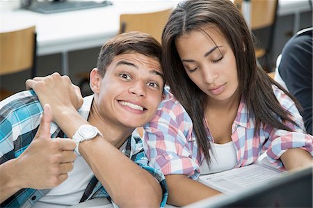 Portrait of teenage boy with cheesy grin and girl with eyes closed in class Stock Photo - Premium Royalty-Free, Code: 649-08306325