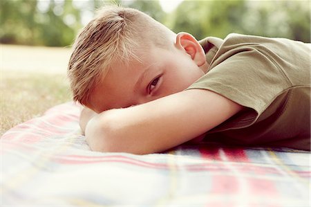 simsearch:649-09078617,k - Surface level view of boy lying on picnic blanket, face obscured looking at camera Stock Photo - Premium Royalty-Free, Code: 649-08306419