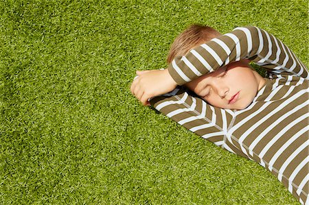 simsearch:649-09078617,k - High angle view of boy lying on grass shielding face eyes closed Stock Photo - Premium Royalty-Free, Code: 649-08306430