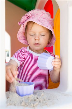 playhouse (children's toy) - Female toddler playing with sand on playhouse windowsill Stock Photo - Premium Royalty-Free, Code: 649-08306540