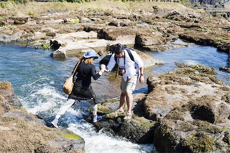 Couple crossing river,  near Victoria Falls, Zambia Stock Photo - Premium Royalty-Free, Code: 649-08306575