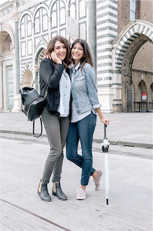 Lesbian couple talking on cellular phone holding umbrella looking at camera smiling, Piazza Santa Maria Novella, Florence, Tuscany, Italy Stock Photo - Premium Royalty-Free, Code: 649-08306695